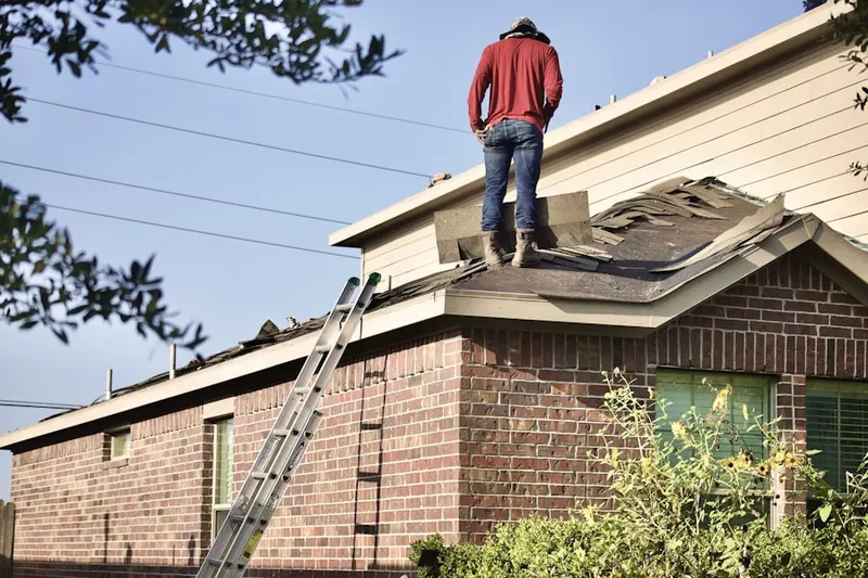 Professional roofer working on a residential roof in Guntown